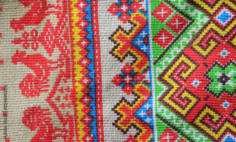 folk textile ornament of bright colors, consisting of patterns of geometric shapes and lines and chicken