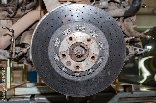 Ceramic brake disc from a perforated vehicle with a floating mounting system mounted on the hub of the vehicle during an upgrade in a vehicle repair shop auto service