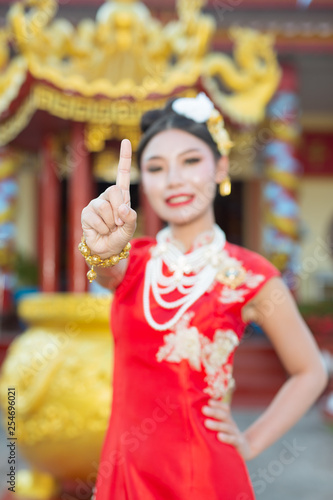 A beautiful asian girl wearing a red suit showing her gestures and smiling makes her look happy.