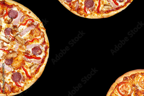 Fresh pizza with meat beaf chicken pork, tomatoes, vegetables, ushrooms on dark black background closeup photo