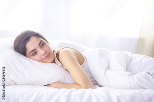 beautiful young woman basking in bed in the morning. Beautiful Model face looks sexy in camera