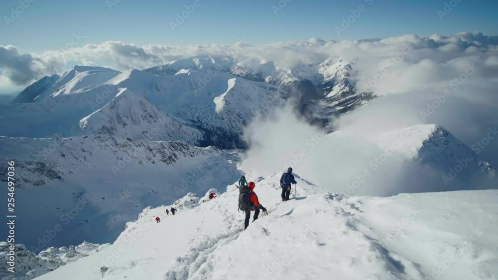A group of climbers ascending a mountain in winter A group of climbers ascending a mountain in winter