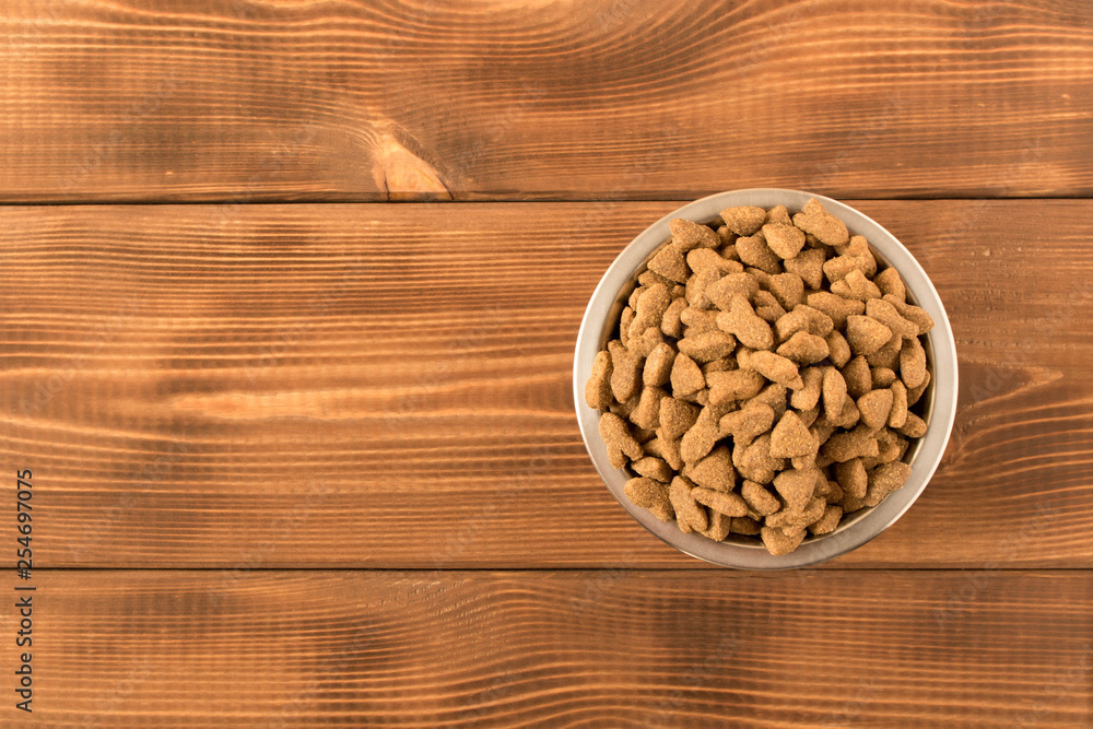 Bowl with dog food on a wooden table. Close up. Bowl with dog food on a wooden table. Close up.
