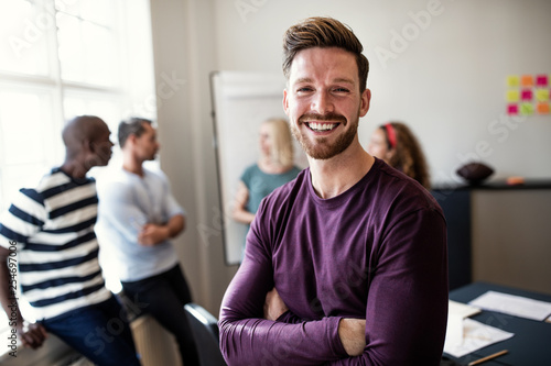 Smiling young designer standing in an office after a presentatio