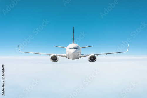 Airplane flies in the sky above a dense layer of clouds.