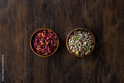 Raw and Roasted Wooden Bowl of Peeled Pistachios without Shell   with No Shell