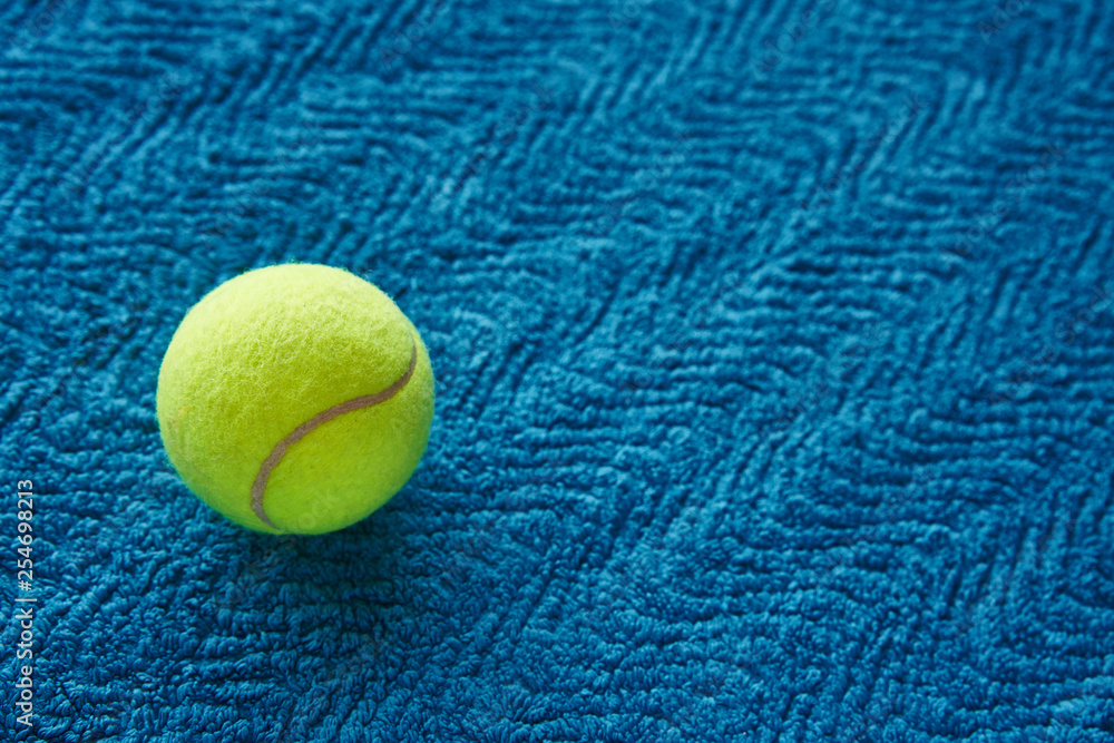Yellow tennis ball on blue towel