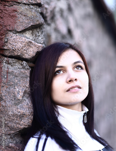 portrait of sad young woman on stone wall background