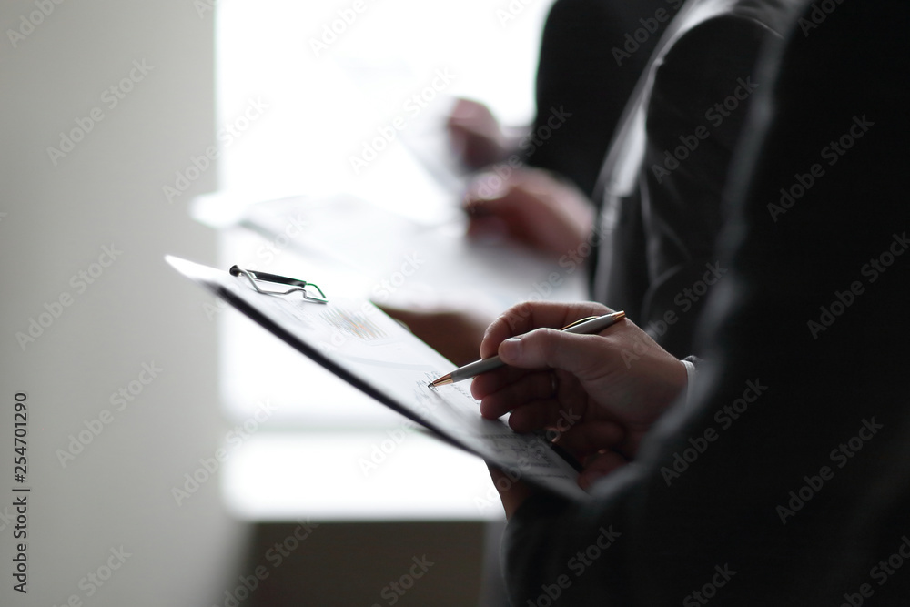 close up.businessman with clipboard checking financial report close up.businessman with clipboard checking financial report