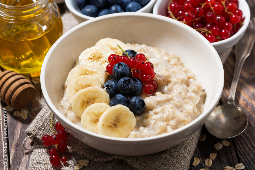 homemade oatmeal with berries on wooden background, closeup homemade oatmeal with berries on wooden background, closeup