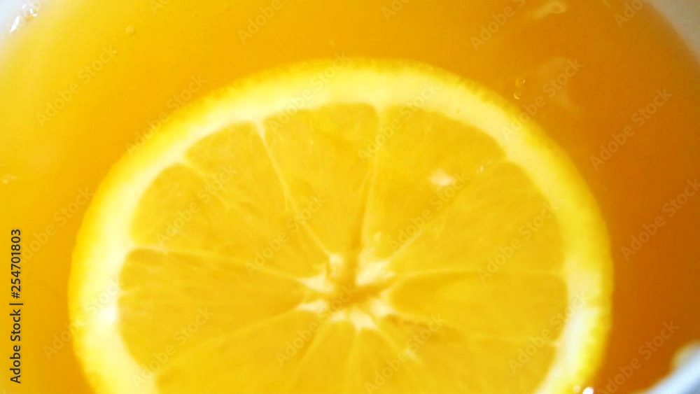 Orange slice falls in fresh juice Orange slice falls in fresh juice