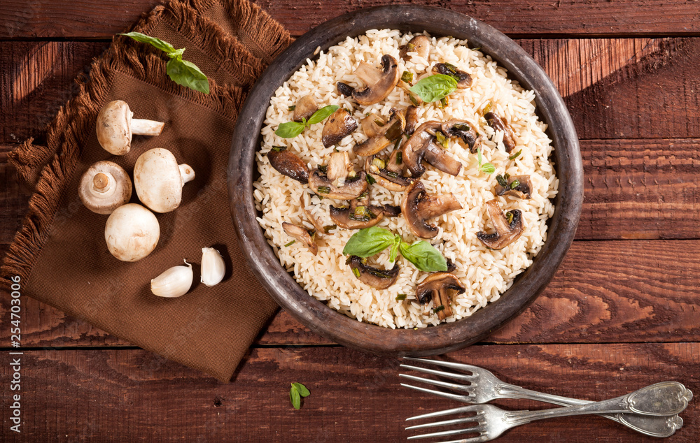Cooked white rice with mushroomsin a bowl on wooden background. Cooked white rice with mushroomsin a bowl on wooden background.