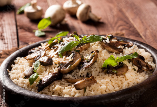 Cooked white rice with mushroomsin a bowl on wooden background. photo