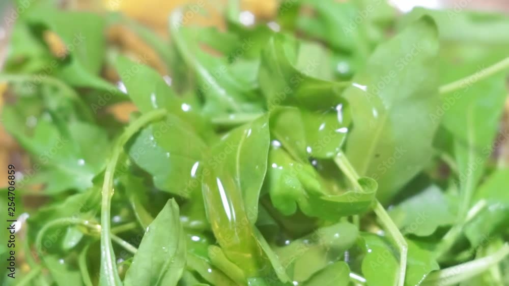 cooking arugula salad add mustard oil close up cooking arugula salad add mustard oil close up
