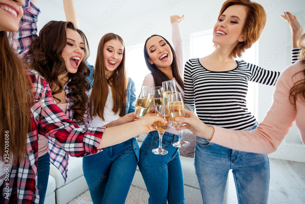 Nice-looking graceful charming attractive cheerful cheery positive ladies wearing casual clinking wine raising hands up in modern light white interior room house indoors Nice-looking graceful charming attractive cheerful cheery positive ladies wearing casual clinking wine raising hands up in modern light white interior room house indoors