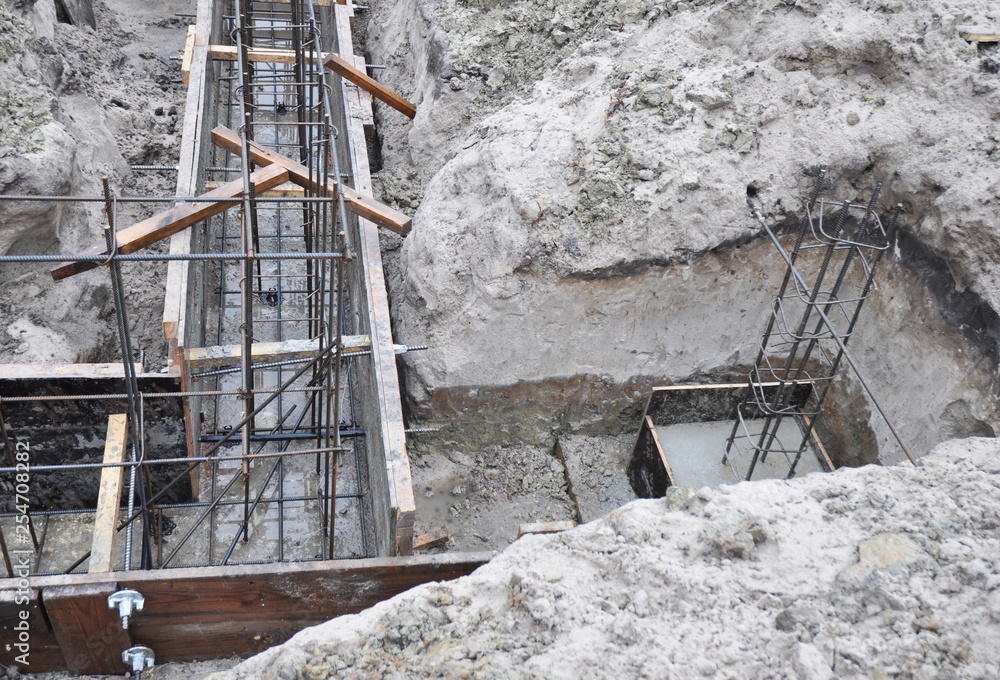 Iron and wooden framework to build a house foundation uder construction.  Incomplete house foundation construction site. Stock Photo | Adobe Stock