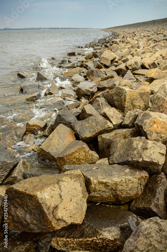 Low water level in the retention reservoir, stony shore.