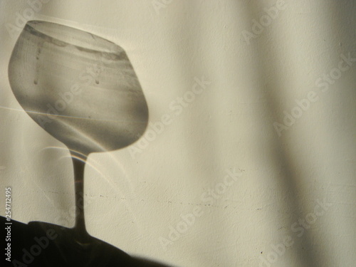 An empty wine glass shadow on the wall