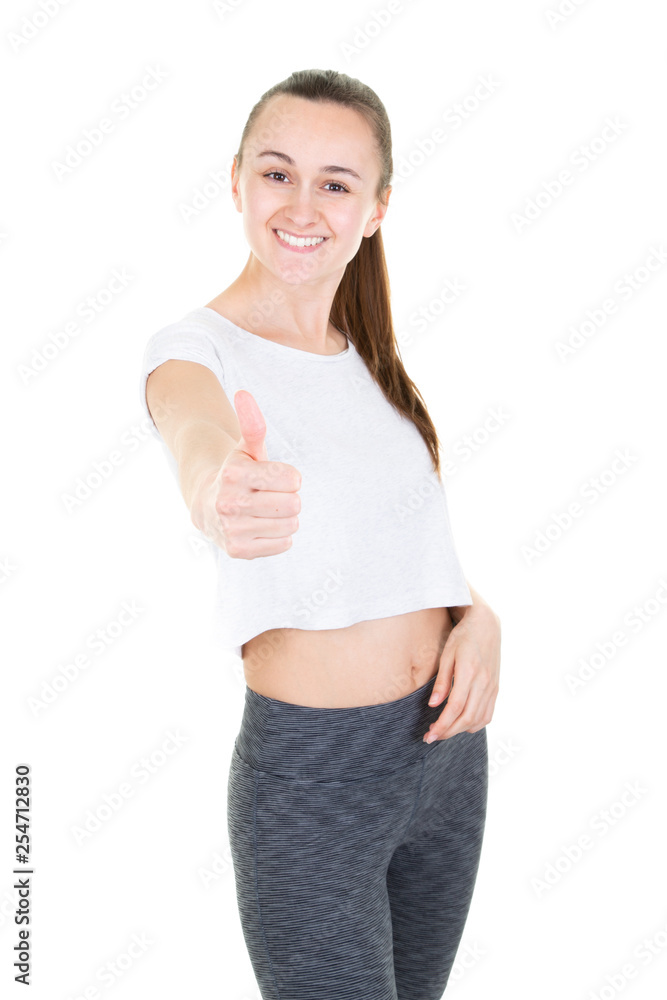Beautiful young woman in sports wear showing with thumb up gesture Beautiful young woman in sports wear showing with thumb up gesture