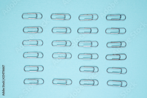 Paper clips laid out on a blue sheet of paper