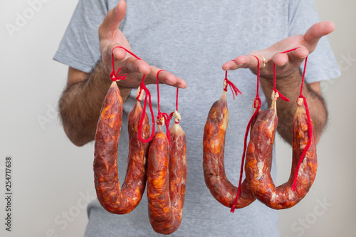 portuguese smoked sausages chourico in mans hands photo