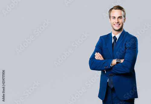 smiling young businessman, on grey