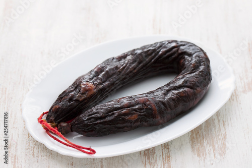 portuguese smoked sausages on white dish on ceramic background photo