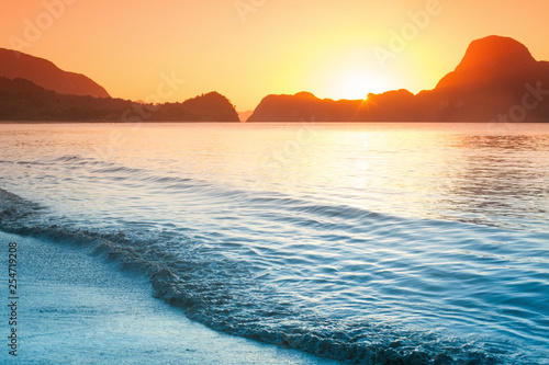 Colorful sunset on a beach with rocks