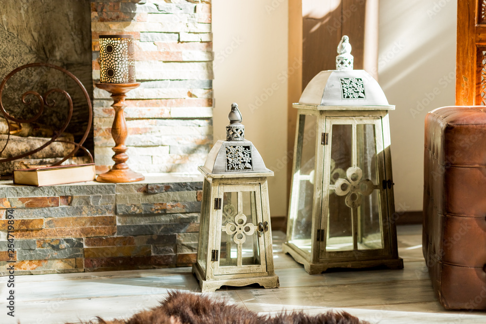 Big candles next to elegant fireplace.white lantern for candle. Closed