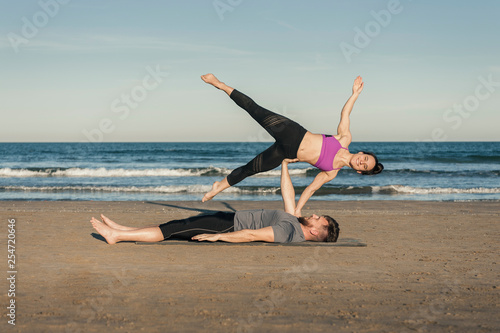 Young couple practicing acroyoga exercise - Side Star
