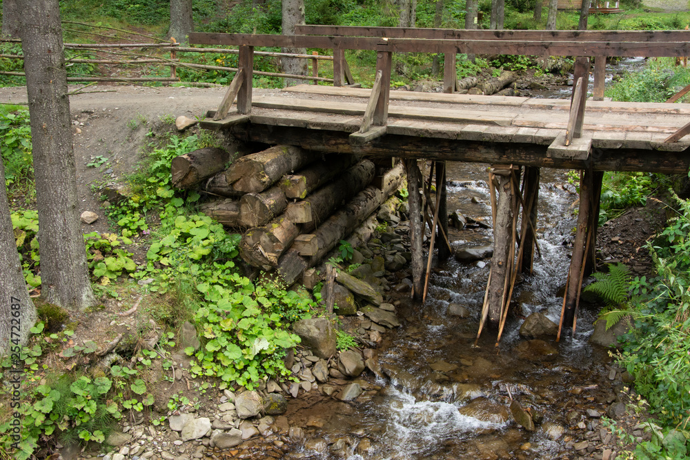 Wooden bridge over the turbulent mountain river.