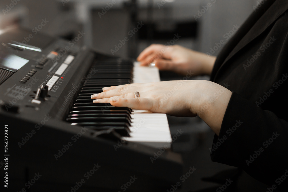 Close up of woman's hand playing the piano. Woman playing on electric piano. Female synthesizer player