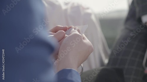 Wallpaper Mural Mans and womans hands hide small paper in them hands and write letter M on it, woman also hold metal hearts in hands. Torontodigital.ca