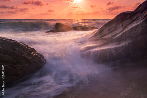 Beautiful natural seascape wave moving on the rock during sunrise