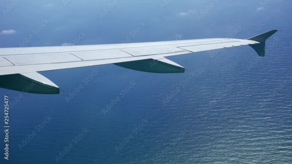 POV view from plane window of beautiful panorama of turquoise Mediterranean sea from seat near aircraft wing. First point view of airplane flying in slow motion POV view from plane window of beautiful panorama of turquoise Mediterranean sea from seat near aircraft wing. First point view of airplane flying in slow motion