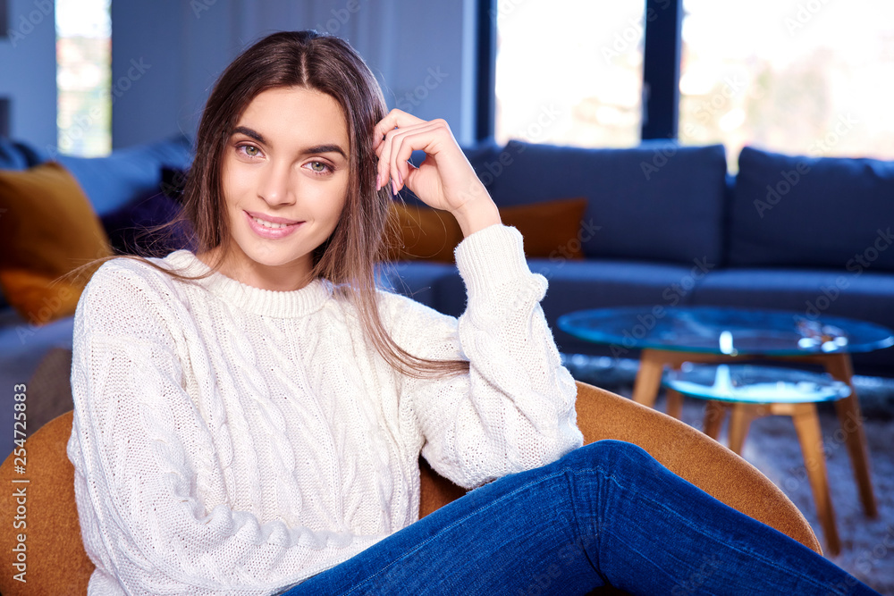 Cheerful young woman relaxing on sofa at home Cheerful young woman relaxing on sofa at home