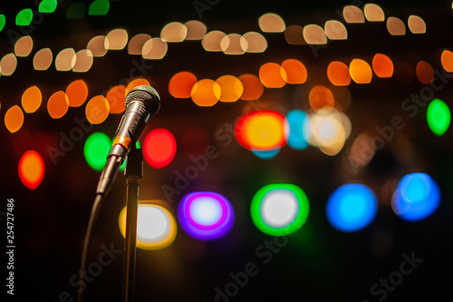 Microphone stands awaiting a performer under the shine of bright stage lights