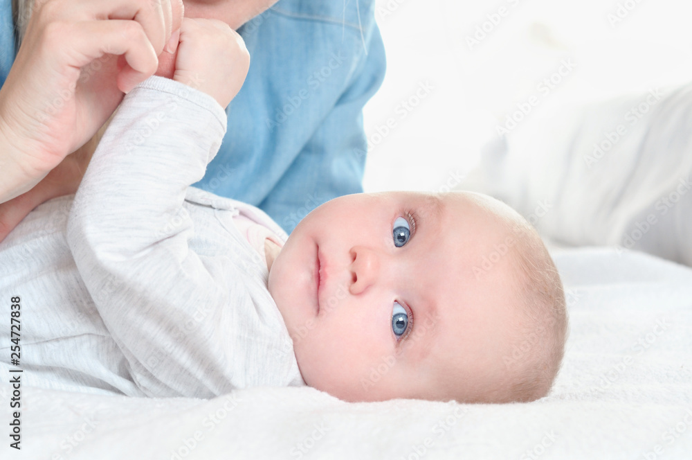 Mother play with her daughter on white bed background Mother play with her daughter on white bed background