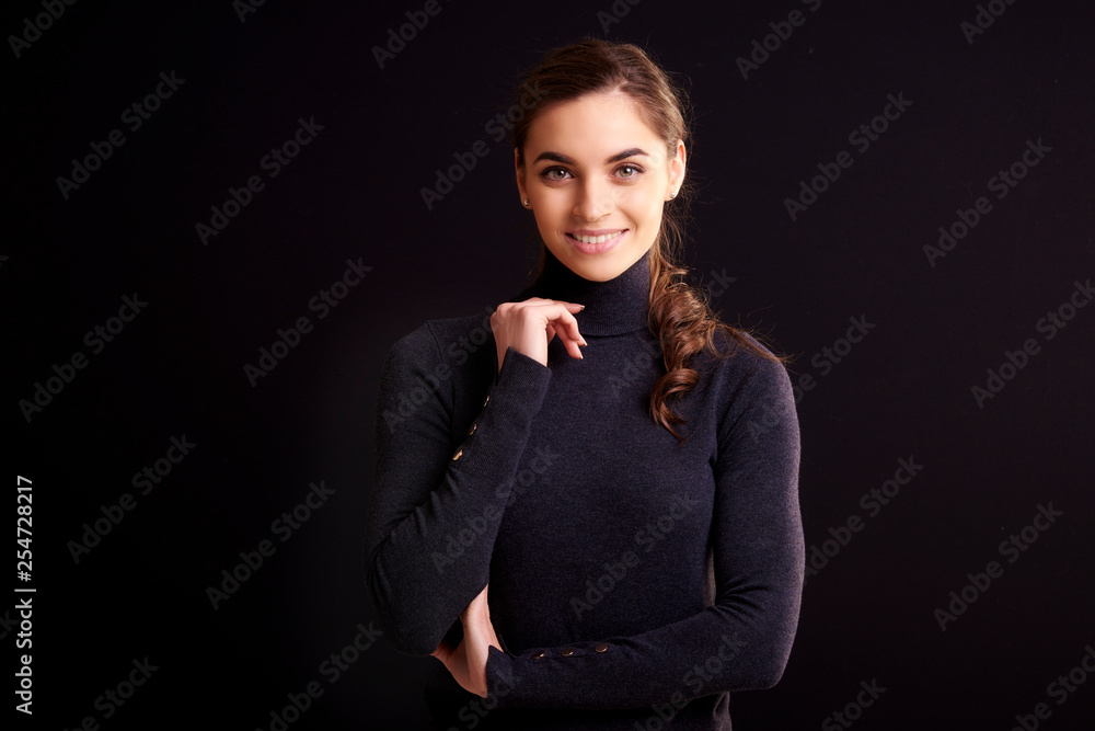 Beautiful smiling woman posing at isolated black background Beautiful smiling woman posing at isolated black background