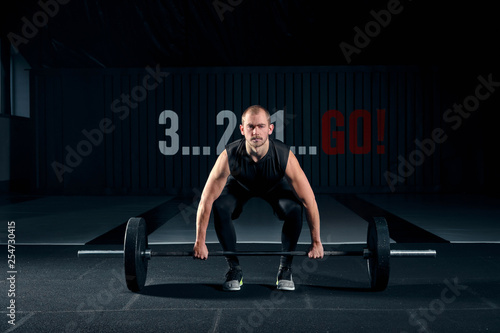 Muscular man bodybuilder training in gym and posing.