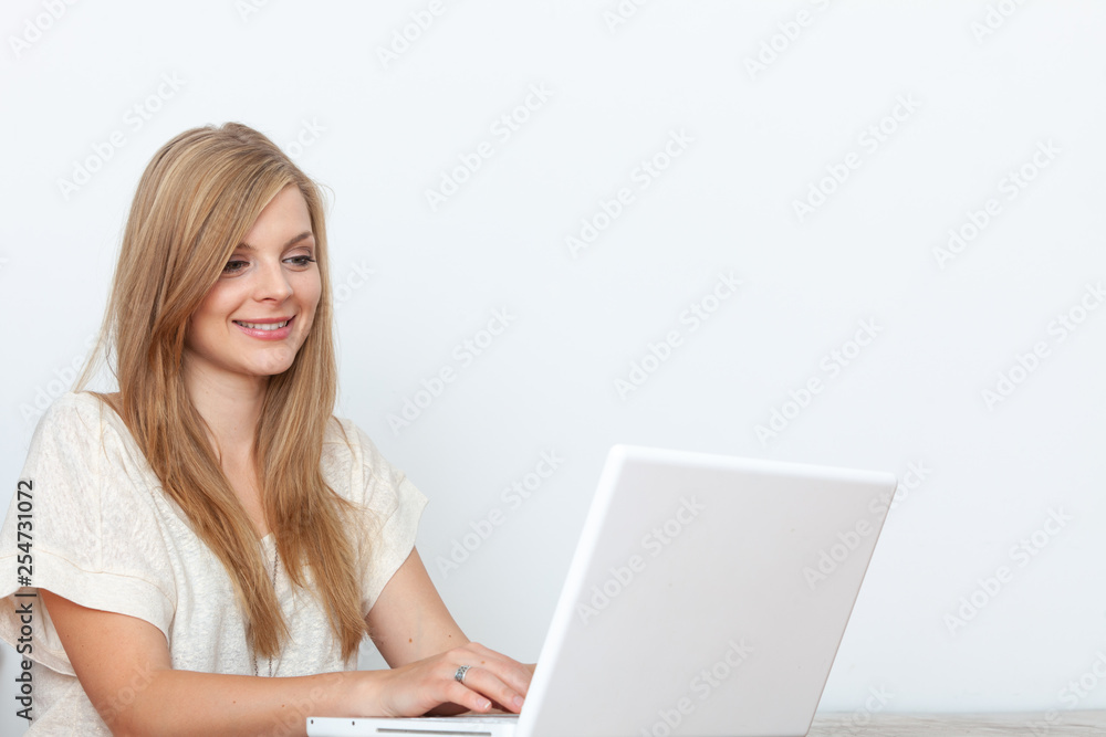 Young woman using a notebook computer indoors Young woman using a notebook computer indoors