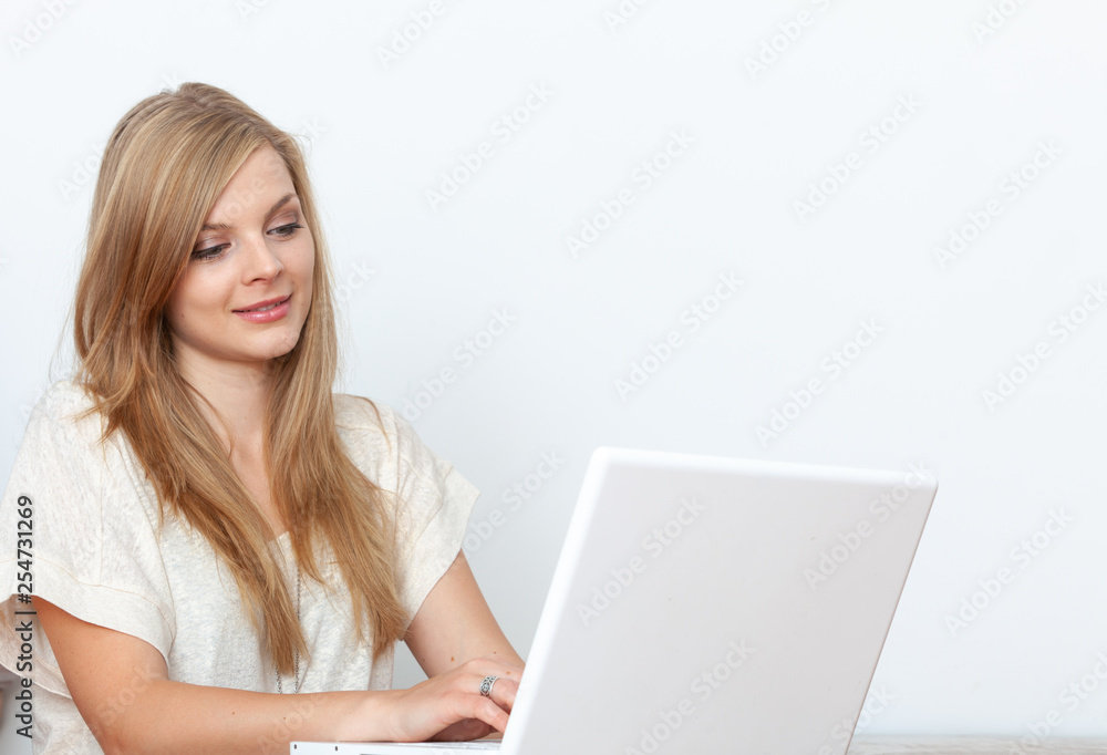 Young woman using a notebook computer indoors Young woman using a notebook computer indoors