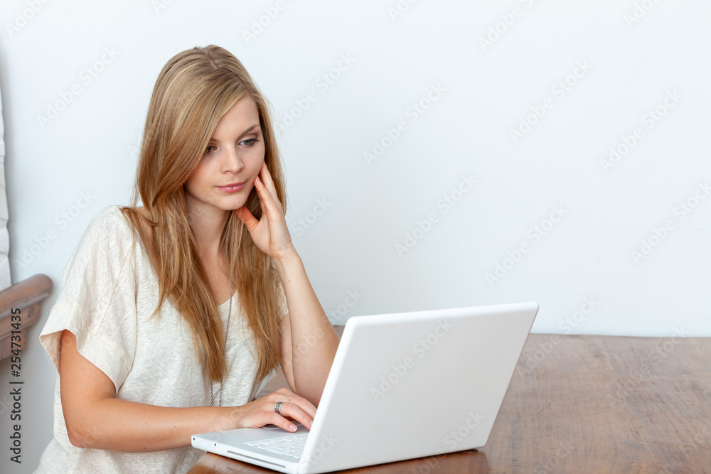 Young woman using a notebook computer indoors Young woman using a notebook computer indoors