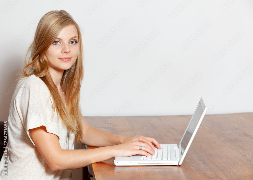 Young woman using a notebook computer indoors Young woman using a notebook computer indoors