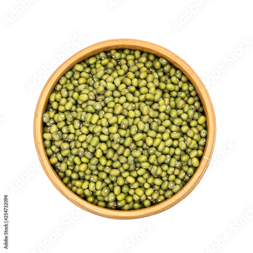 Mung beans in a wooden bowl seen directly from above and isolated on white