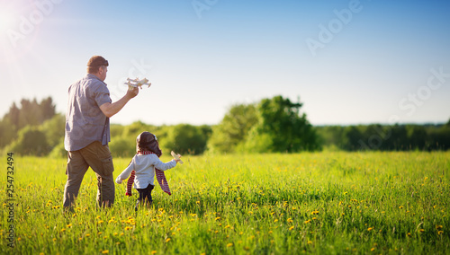 Boy playing in aviator hat with old plane