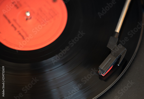 A vinyl record plays on a turn table record player photo