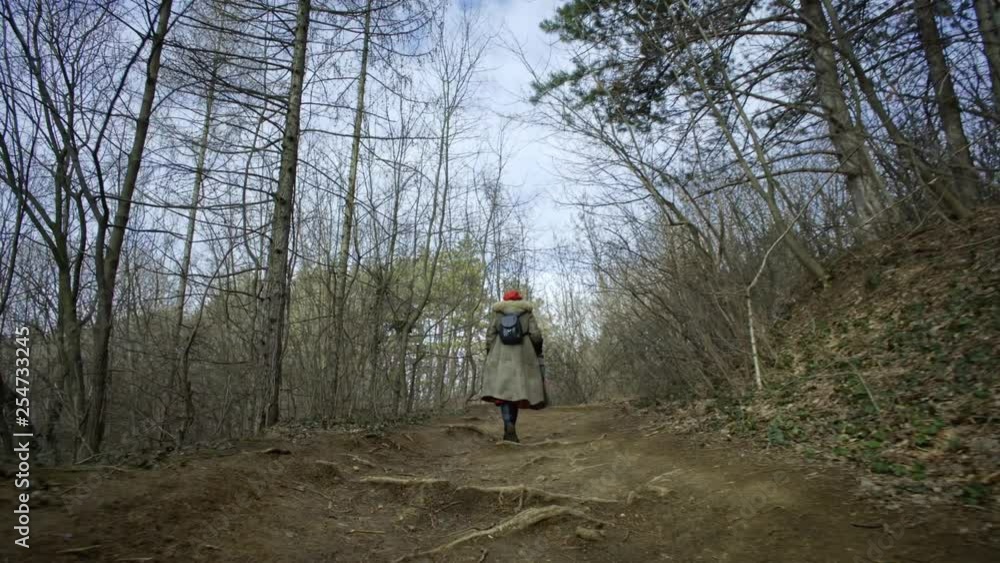 Young attractive woman with red hat wanders in forest Young attractive woman with red hat wanders in forest