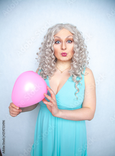 pretty blonde cheerful girl with pink air balloon on white studio background © goldeneden