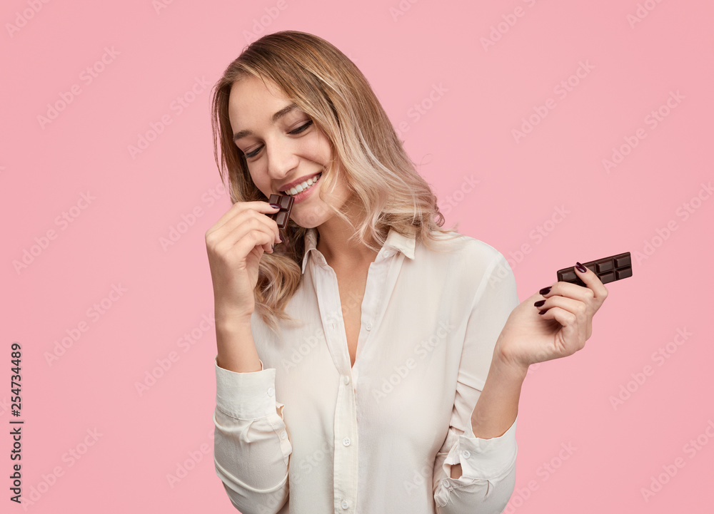 Cheerful female eating chocolate Cheerful female eating chocolate